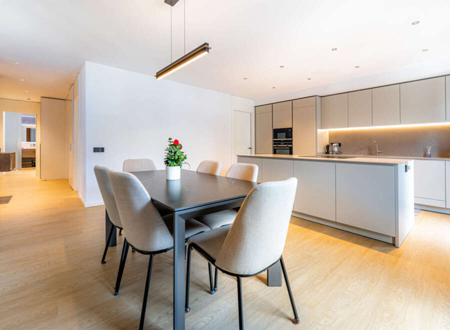 Experience modern living in this stunning open-concept space, featuring a sleek dining area with a contemporary table and chairs, perfect for intimate gatherings.