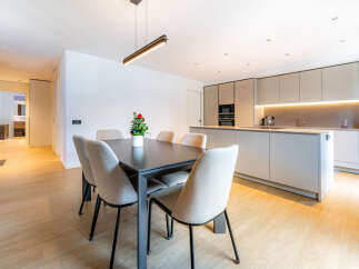 Experience modern living in this stunning open-concept space, featuring a sleek dining area with a contemporary table and chairs, perfect for intimate gatherings.