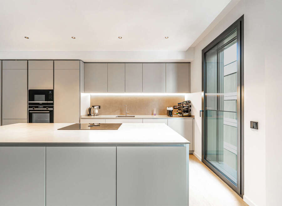 Experience modern living in this sleek kitchen featuring a spacious island with a built-in stovetop, perfect for culinary creations.
