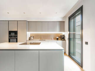 Experience modern living in this sleek kitchen featuring a spacious island with a built-in stovetop, perfect for culinary creations.