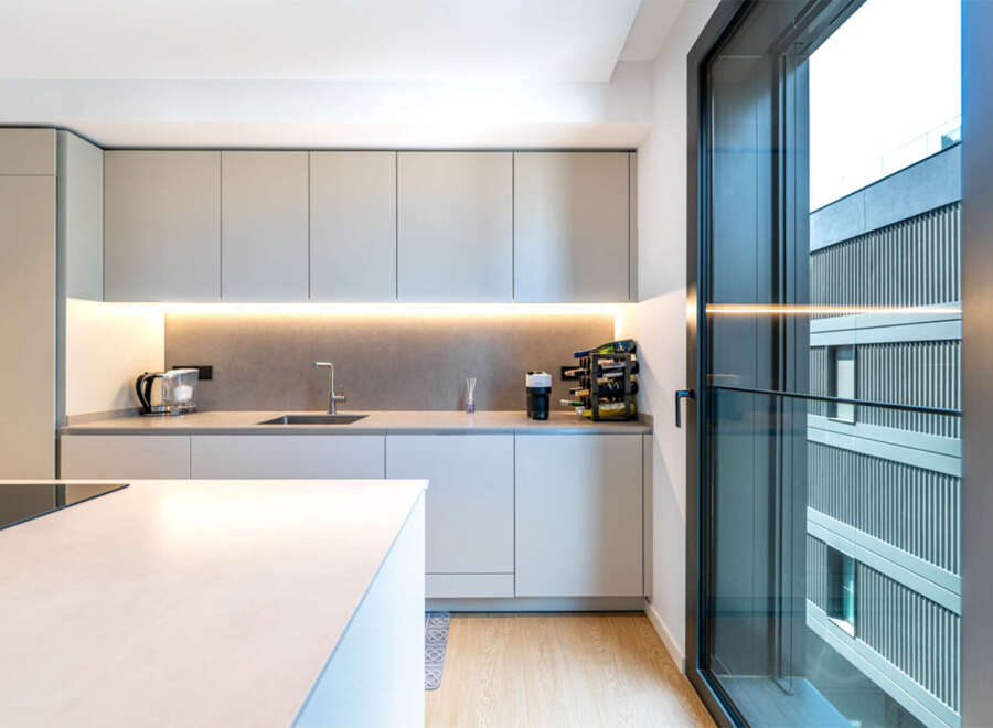 Experience modern living in this sleek kitchen, featuring minimalist cabinetry and integrated lighting for a sophisticated ambiance.