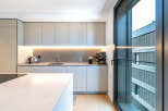 Experience modern living in this sleek kitchen, featuring minimalist cabinetry and integrated lighting for a sophisticated ambiance.