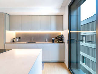 Experience modern living in this sleek kitchen, featuring minimalist cabinetry and integrated lighting for a sophisticated ambiance.