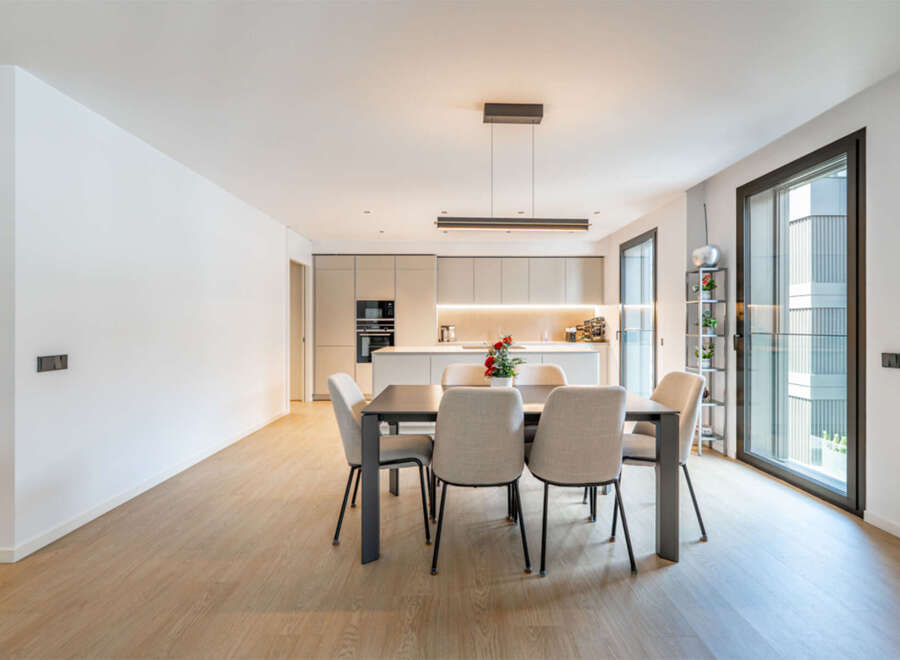 Experience modern living in this stunning open-concept space, featuring a sleek dining area perfect for gatherings and a contemporary kitchen with ample cabinetry and integrated appliances.