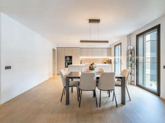 Experience modern living in this stunning open-concept space, featuring a sleek dining area perfect for gatherings and a contemporary kitchen with ample cabinetry and integrated appliances.
