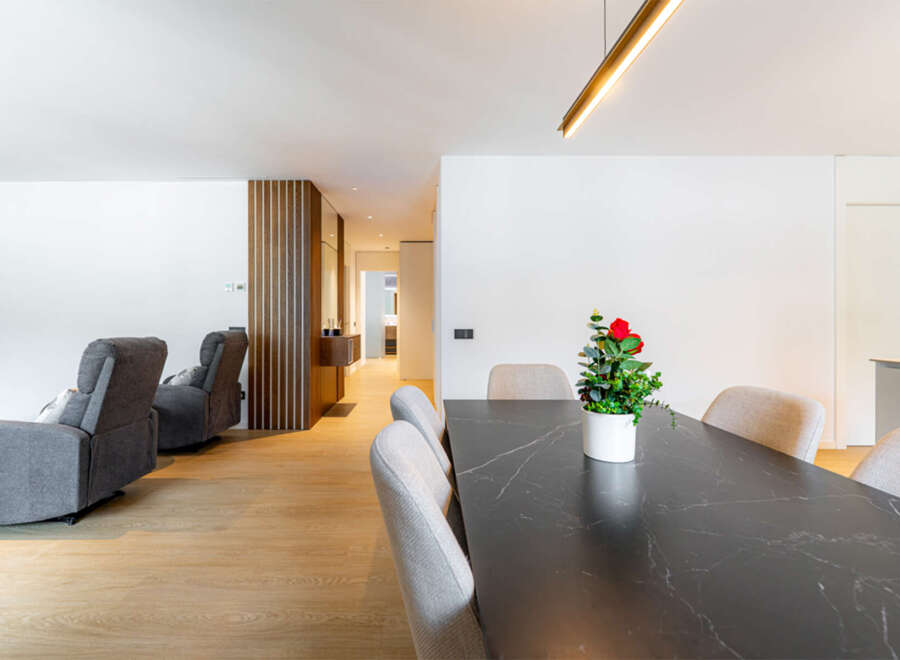 Experience modern living in this spacious open-concept home, featuring a sleek dining area with a marble-top table and comfortable seating.