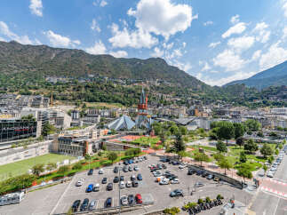 Discover this vibrant urban landscape nestled against a majestic mountain backdrop.