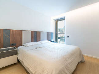 Experience modern comfort in this beautifully appointed bedroom, featuring a plush bed with a striking, multi-textured headboard.