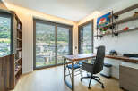 This modern home office features a spacious wooden desk with comfortable seating, perfect for productivity.
