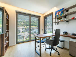 This modern home office features a spacious wooden desk with comfortable seating, perfect for productivity.