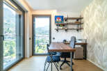 This modern home office features a spacious wooden desk with ergonomic chairs, perfect for productive work sessions.