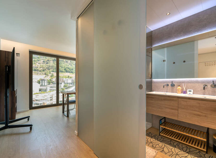 Experience modern living in this stylish apartment featuring a spacious living area with a large window offering scenic views.