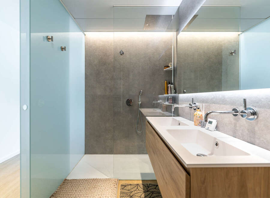 Experience modern luxury in this stunning bathroom featuring a spacious walk-in shower with a rainfall showerhead and sleek, minimalist design.