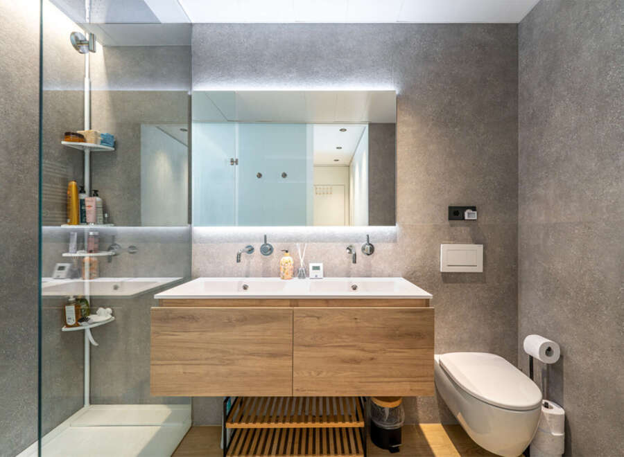 Experience modern luxury in this stunning bathroom featuring a sleek double vanity with ample storage and elegant wood cabinetry.