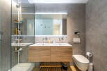 Experience modern luxury in this stunning bathroom featuring a sleek double vanity with ample storage and elegant wood cabinetry.
