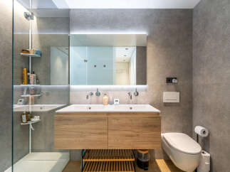 Experience modern luxury in this stunning bathroom featuring a sleek double vanity with ample storage and elegant wood cabinetry.