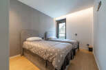 This modern bedroom features two comfortable twin beds, each adorned with a charming star-patterned duvet and plush grey throws.