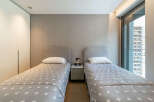 Discover this modern bedroom featuring two comfortable twin beds, each adorned with a charming star-patterned duvet and a plush white pillow.