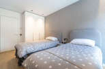 This modern bedroom features two twin beds with playful star-patterned comforters, perfect for a child's room or guest suite.
