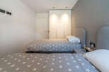 This modern bedroom features two twin beds with charming star-patterned comforters, perfect for a guest room or children's space.
