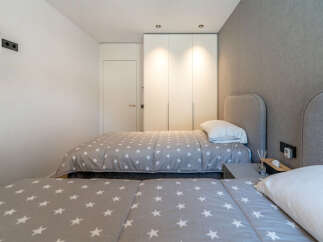 This modern bedroom features two twin beds with charming star-patterned comforters, perfect for a guest room or children's space.