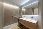Experience modern luxury in this stunning bathroom featuring a spacious walk-in shower with a rainfall showerhead and sleek glass enclosure.