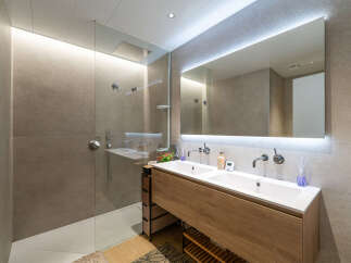 Experience modern luxury in this stunning bathroom featuring a spacious walk-in shower with a rainfall showerhead and sleek glass enclosure.