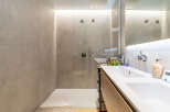 Experience modern luxury in this stunning bathroom featuring a spacious walk-in shower with sleek fixtures and a double vanity with ample counter space.
