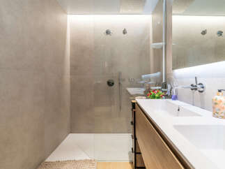 Experience modern luxury in this stunning bathroom featuring a spacious walk-in shower with sleek fixtures and a double vanity with ample counter space.