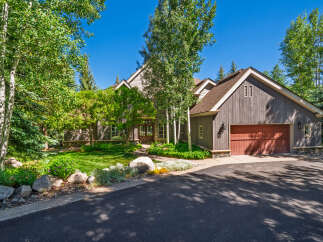 Nestled amidst lush greenery and mature trees, this stunning mountain home offers a serene retreat.