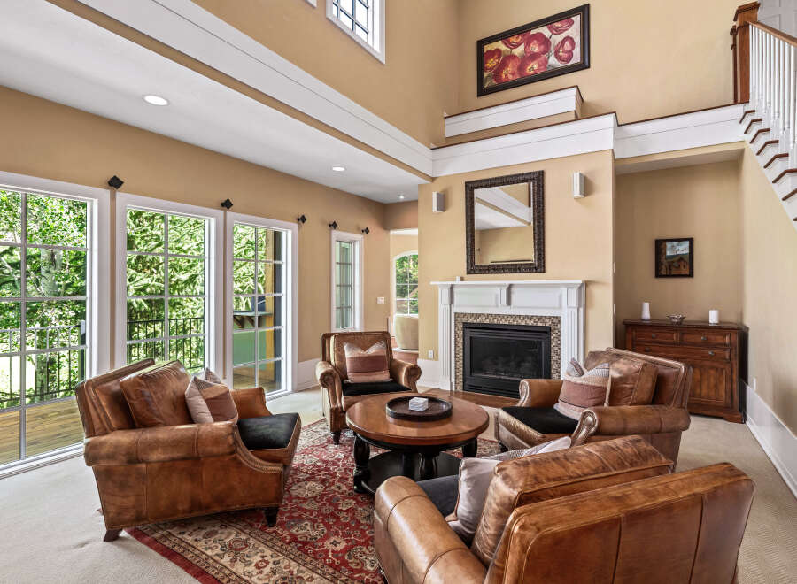 Step into this inviting living room featuring plush leather armchairs arranged around a central coffee table, perfect for intimate gatherings.