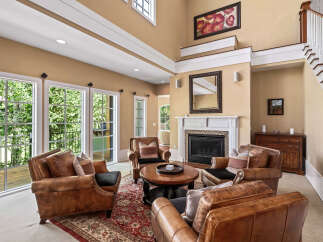 Step into this inviting living room featuring plush leather armchairs arranged around a central coffee table, perfect for intimate gatherings.