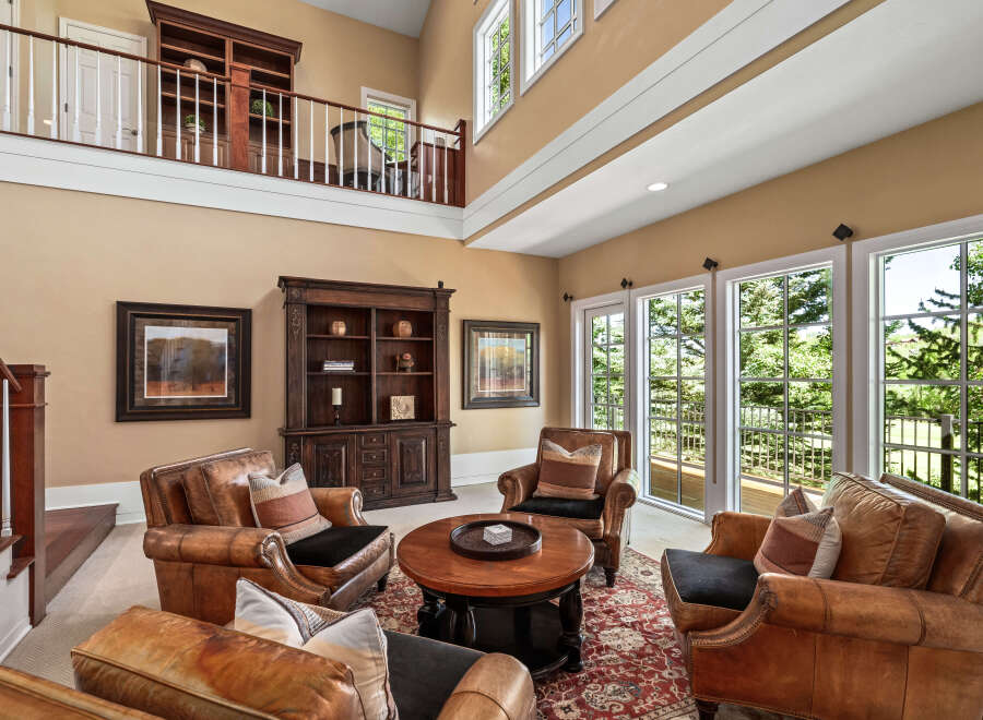 Experience luxurious living in this grand living room, featuring plush leather armchairs arranged around a central coffee table, perfect for intimate gatherings.