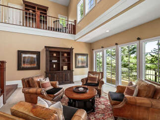 Experience luxurious living in this grand living room, featuring plush leather armchairs arranged around a central coffee table, perfect for intimate gatherings.