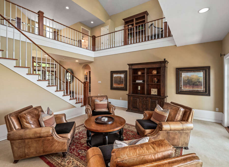 Step into this grand living space featuring a stunning two-story staircase and a loft overlooking the main floor.