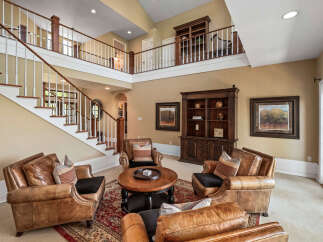 Step into this grand living space featuring a stunning two-story staircase and a loft overlooking the main floor.