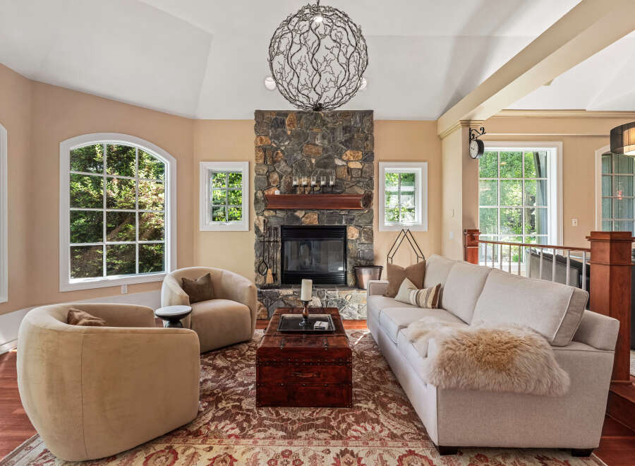 Experience luxurious living in this stunning living room, featuring a grand stone fireplace as the centerpiece.