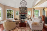 Experience luxurious living in this stunning living room, featuring a grand stone fireplace as the centerpiece.