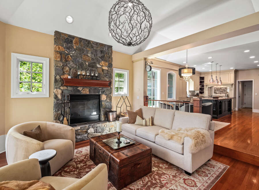 Experience luxury living in this stunning home featuring a grand stone fireplace and an open-concept layout connecting to a gourmet kitchen.
