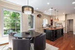 Experience luxury in this stunning kitchen, featuring a large granite island perfect for entertaining and a charming breakfast nook with a round table and plush seating.