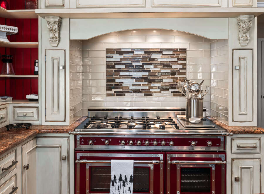 Experience culinary excellence in this stunning kitchen, featuring a professional-grade range with dual ovens and a gas cooktop.