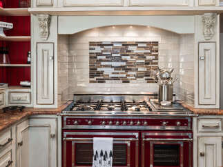 Experience culinary excellence in this stunning kitchen, featuring a professional-grade range with dual ovens and a gas cooktop.