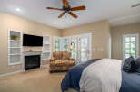 Experience ultimate comfort in this beautifully appointed bedroom, featuring a cozy fireplace and a large flat-screen TV for entertainment.