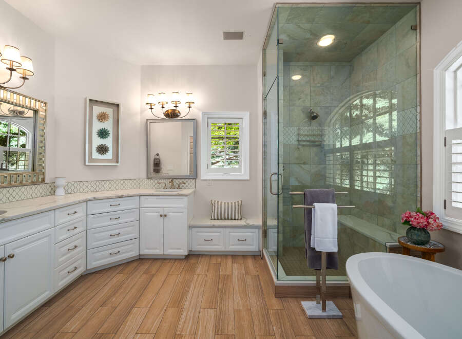 Experience luxury in this stunning bathroom featuring a spacious walk-in shower with elegant tilework and a freestanding soaking tub.