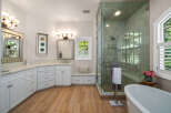 Experience luxury in this stunning bathroom featuring a spacious walk-in shower with elegant tilework and a freestanding soaking tub.