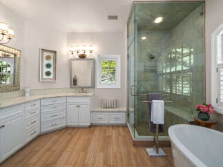 Experience luxury in this stunning bathroom featuring a spacious walk-in shower with elegant tilework and a freestanding soaking tub.