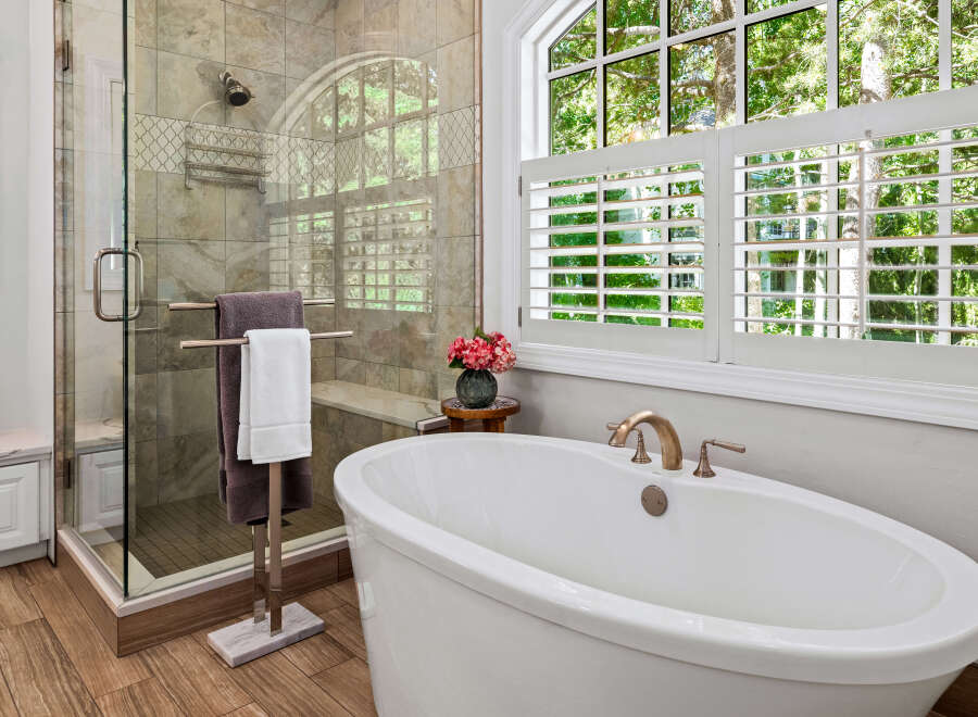 Indulge in luxury with this stunning bathroom featuring a freestanding soaking tub and a spacious glass-enclosed shower.