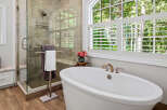Indulge in luxury with this stunning bathroom featuring a freestanding soaking tub and a spacious glass-enclosed shower.