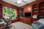 This home office features custom cherry wood built-in bookshelves and cabinetry, providing ample storage and a sophisticated aesthetic.