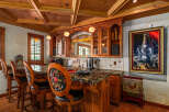 Step into this elegant home bar, featuring a stunning granite countertop and rich wooden cabinetry.